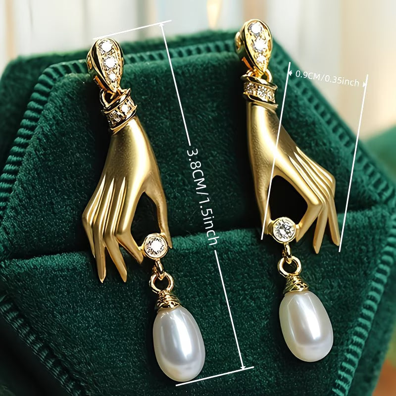 Pendientes de perla y mano