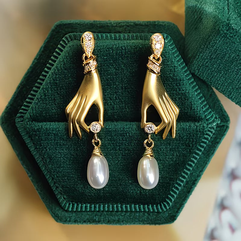 Pendientes de perla y mano